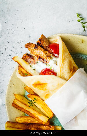 Les gyros souvlaki s'enroule dans le pain pita au poulet, pommes de terre et sauce tzatziki, copiez l'espace. Banque D'Images