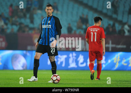 Ancien footballeur italien Marco Materazzi, gauche, d'Inter pour toujours se prépare à lancer la balle pour faire une passe contre un joueur de l'étoile tous les Chinois Banque D'Images