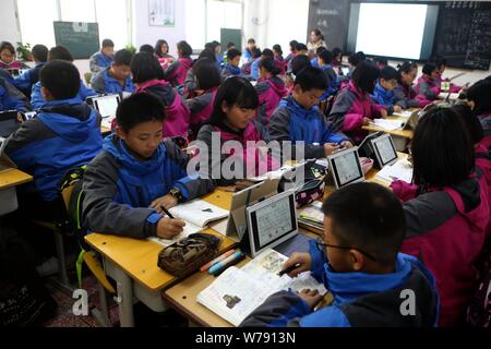 Les élèves chinois utiliser PC tablettes comme outils d'apprentissage pendant une leçon à un middle school à Zhengzhou, province du Henan en Chine centrale, le 16 novembre 2017 Banque D'Images