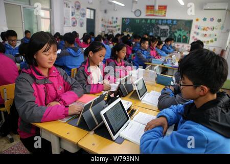 Les élèves chinois utiliser PC tablettes comme outils d'apprentissage pendant une leçon à un middle school à Zhengzhou, province du Henan en Chine centrale, le 16 novembre 2017 Banque D'Images