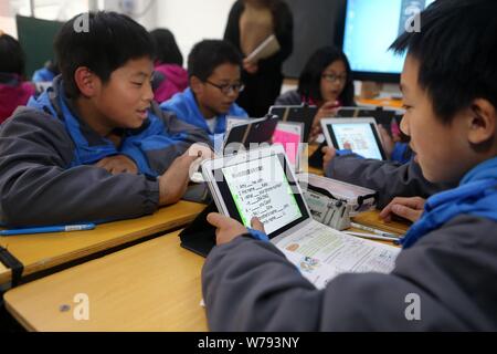 Les élèves chinois utiliser PC tablettes comme outils d'apprentissage pendant une leçon à un middle school à Zhengzhou, province du Henan en Chine centrale, le 16 novembre 2017 Banque D'Images