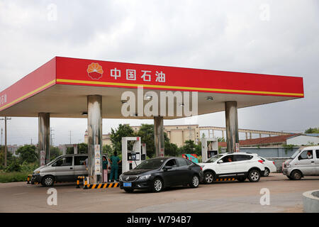 --FILE--voitures font la queue jusqu'à faire le plein à une station-service de la CNPC (China National Petroleum Corporation), la société mère de PetroChina, dans la ville de Nantong, e Banque D'Images