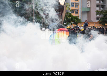 Les protestataires s'enfuient de gaz lacrymogènes tirés par la police au cours de la manifestation.L'agitation à Hong Kong continuent comme protestataires propose de fermer le centre financier d'Asie avec une grève générale le lundi après un week-end de droite neuvième manifestations anti-gouvernementales. La grève générale a fait que le transport public n'offrant que des services limités en raison du manque de personnel. Des centaines de vols voler dans et hors de l'aéroport international de Hong Kong tous les avait été annulée comme nombre de membres du personnel de contrôle de la circulation aérienne ont été en grève. Banque D'Images