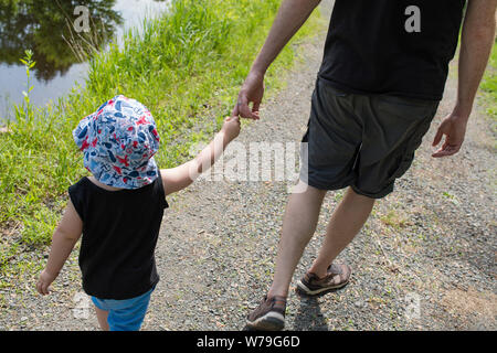 Un père et son fils passent à côté d'un lac. Banque D'Images