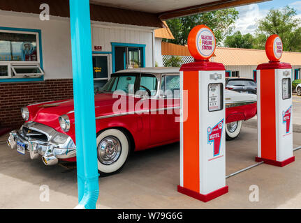 1955 Studebaker President classic voiture garée en face de pompes à essence anciens chargeurs de voiture électrique reconvertie à ; l'Circle R Motel ; Salida ; Colorado, États-Unis Banque D'Images