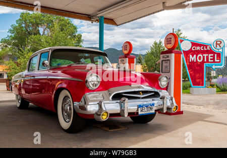 1955 Studebaker President classic voiture garée en face de pompes à essence anciens chargeurs de voiture électrique reconvertie à ; l'Circle R Motel ; Salida ; Colorado, États-Unis Banque D'Images