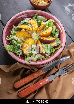 Close-up avec des feuilles de salade vegan romano et poêlée de pêche. Shot verticale Banque D'Images