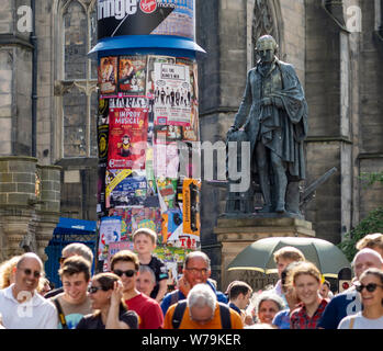 La statue d'Adam Smith regarde vers le bas sur les carnavaliers à l'Edinburgh Festival Fringe 2019 - The Royal Mile, Édimbourg, Écosse, Royaume-Uni. Banque D'Images