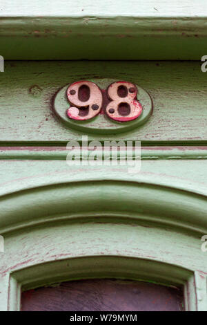 Numéro de maison 98 sur une petite plaque au-dessus d'une porte sculptée Banque D'Images