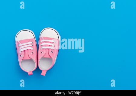 Chaussures Bébé rose sur un fond bleu avec l'espace pour le texte. Vue d'en haut Banque D'Images