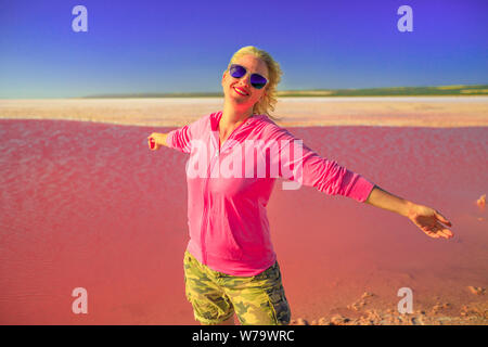 Liberté femme caucasienne à bras ouverts au lac Pink à Port Gregory, Australie occidentale. Touriste blond à Hutt Lagoon, Australie. Ciel bleu en été Banque D'Images