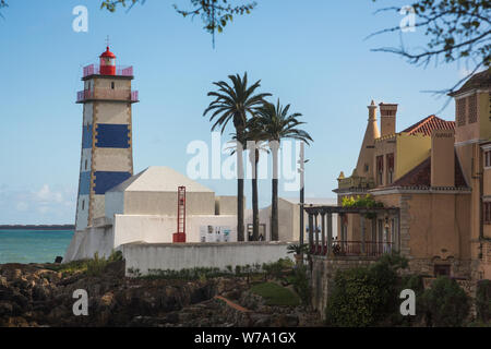 Vue sur le phare de Santa Marta à rayures bleues et blanches (Farol de Santa Marta) surplombant la baie de Cascais à Cascais, au Portugal. Banque D'Images