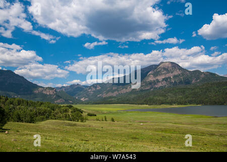 Les prairies luxuriantes et lac ci-dessous les Rocheuses et un ciel bleu avec des nuages blancs près de Pagosa Springs, Colorado Banque D'Images