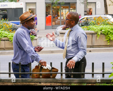 Deux hommes absorbés dans des conversations. Michigan Avenue, Chicago, Illinois. Banque D'Images