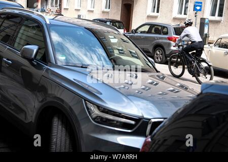 Munich, Allemagne. Le 05 août, 2019. Un SUV se tient sur le côté de la route, derrière un cycliste roule sur la route. Le Gouvernement fédéral Administration des transports (KBA) publie de nouveaux chiffres sur l'utilisation des VUS en Allemagne le 06.08.2019. (Zu dpa 'Agence fédérale de l'environnement : faire de l'achat de voitures avec des émissions de CO2 plus cher' à partir de 06.08.2019) Crédit : Sina Schuldt/dpa/Alamy Live News Banque D'Images