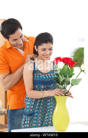 Young man putting on necklace around his wife neck Stock Photo