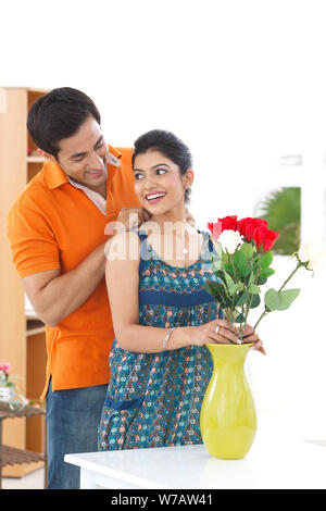 Young man putting on necklace around his wife neck Stock Photo