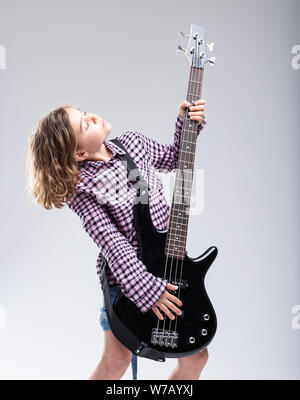 Jeune fille de talent avec un don pour la guitare jouant une guitare électrique pendant une performance live avec une expression d'inspiration absorbée Banque D'Images