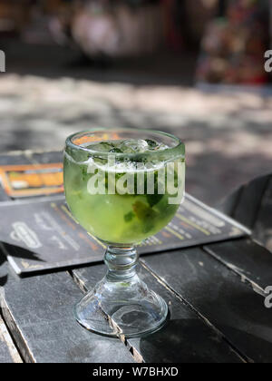 Un verre de mojito sur une table dans un bar mexicain. Le Mojito dans l'original est en verre à côté du menu. Banque D'Images