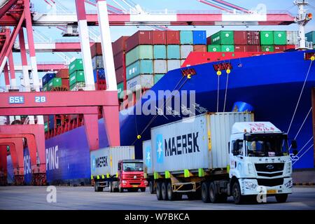 Les conteneurs de transport des camions pour être expédiés à l'étranger, sur un quai du port de Qingdao en Qingdao city, province de Shandong en Chine orientale, le 13 octobre 2017. Banque D'Images