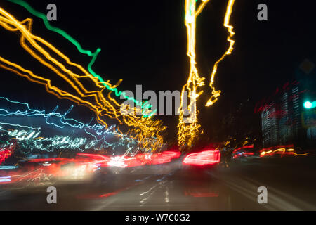 Flou artistique floue Lumières de fort trafic sur un pluvieux humide. feux de circulation dans le motion blur. Banque D'Images