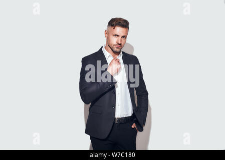 Photo en studio d'un homme d'affaires barbu dans une chemise à réglage de costume classique et regardant l'appareil photo tout en se tenant debout sur fond gris. Aspect professionnel. Prise de vue en studio Banque D'Images