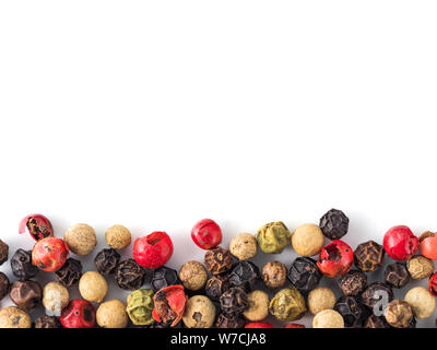 Poivre blanc avec fond mixte de l'espace de copie dans le centre. Arrière-plan de l'alimentation avec des grains de poivre. Poivre de différentes couleurs sur fond blanc, vue de dessus ou de mise à plat Banque D'Images