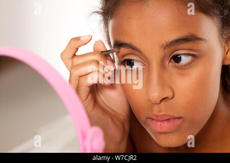 Belle jeune femme noire qui épilent les sourcils Banque D'Images