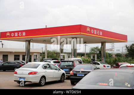 --FILE--voitures font la queue jusqu'à faire le plein à une station-service de la CNPC (China National Petroleum Corporation), la société mère de PetroChina, dans la ville de Nantong, e Banque D'Images