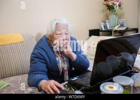 --FILE--une femme âgée utilise son ordinateur portable pour faire des achats en ligne à la ville de Hangzhou, Zhejiang Province de Chine orientale, 6 janvier 2017. Dans la pa Banque D'Images