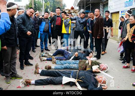 Les fils d'une femme âgée surnommée Wang qui est mort à 86 ans ancien rouleau sur le sol pour exprimer l'amour et le dévouement à leur mère décédée au cours de la fu Banque D'Images