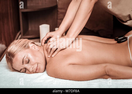 Woman getting son massage après des pierres chaudes. Banque D'Images