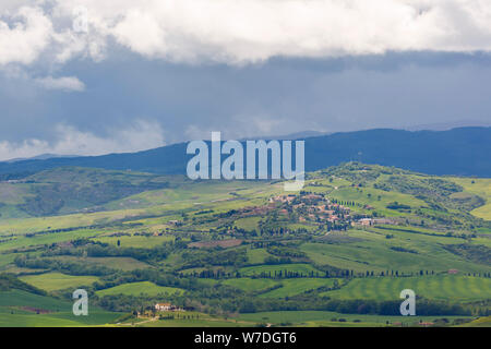 Vue d'une vallée en Toscane avec un village et la pluie nuages dans le ciel Banque D'Images