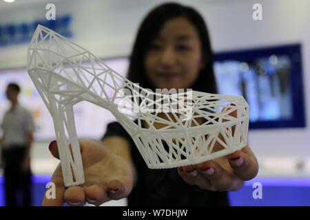 --FILE--un visiteur affiche une 3D printed soulier à haut talon lors d'une expo à Weifang City, Shandong province de Chine orientale, le 28 mai 2014. Le marché chinois Banque D'Images