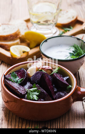 Trempette au yogourt avec le persil, l'aneth et le jus de citron servi sur table en bois rustique avec betteraves rôties, pain et l'eau de citron, Close up, bas usine vegan Banque D'Images