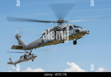 190802-N-PL946-2051 GRANDS LACS, dans l'Illinois (16 août 2000 2, 2019) Deux hélicoptères Seahawk MH-60S de l'Escadron d'hélicoptères de combat de la mer quatre (HSC-4) "Black Knights", basé à San Diego, se préparer à atterrir sur l'une des pelouses à recruter le commandement de l'instruction de rencontrer et leur division commission parrainée recruter. Plus de 35 000 recrues former chaque année à la marine est que boot camp. (U.S. Photo par marine Spécialiste de la communication de masse 1re classe Spencer Fling/libérés) Banque D'Images