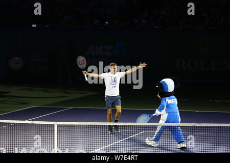 Le joueur de tennis suisse Roger Federer fête avec Mickey Mouse après avoir marqué contre les opposants au cours de journée Famiy Rolex Masters de Shanghai à Qizhong S Banque D'Images