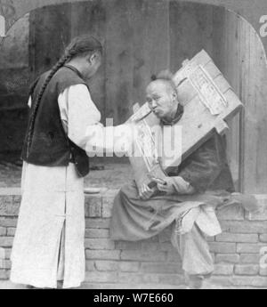 L'alimentation d'un prisonnier portant une cangue, Chine, 1902. Artiste : CH Graves Banque D'Images