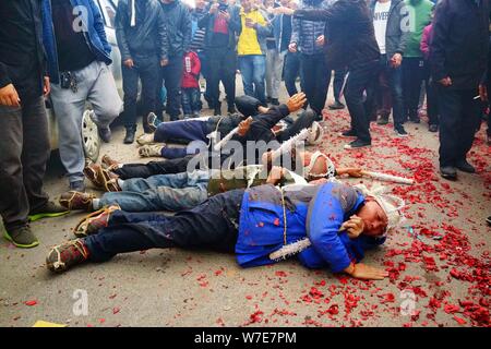 Les fils d'une femme âgée surnommée Wang qui est mort à 86 ans ancien rouleau sur le sol pour exprimer l'amour et le dévouement à leur mère décédée au cours de la fu Banque D'Images