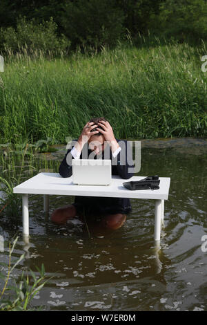 Des troubles de l'homme est déçu par le problème du travail, tenant sa tête. Pense, à la recherche d'une solution à un problème de travail. À la table, l'article i Banque D'Images