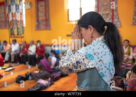 Un adorateur entrant dans le temple bouddhiste de Sherpa dans Queens s'arrête un moment de prière et de méditation. Banque D'Images