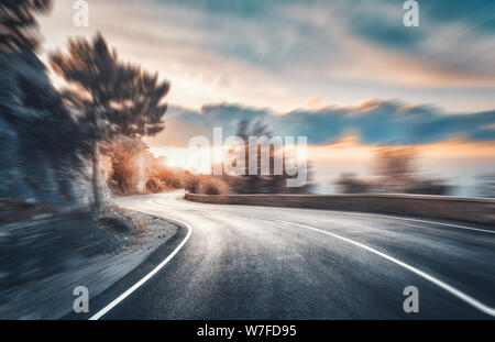 Route de montagne au coucher du soleil avec effet de flou. Route asphaltée Banque D'Images