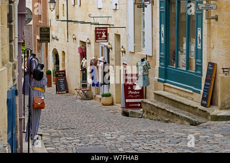 Les nombreuses entreprises et magasins de Saint-Émilion en France, y compris des boutiques, joailliers et caves à vin. Une rue pavée typique. Banque D'Images