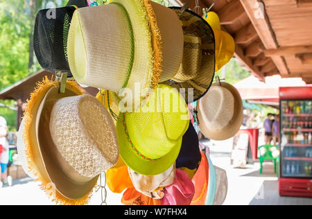 Le genre de paille différentes femmes touristiques des chapeaux qui s'accrochent et sont vendus dans le marché dans la zone de villégiature Banque D'Images