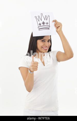 Jeune femme se faisant passer pour une princesse et showing thumb up sign Banque D'Images