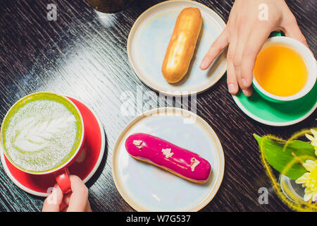 Vitrage sur eclair cerise plat blanc surmonté de griffonner chocolat bonbons servis avec un côté de la bergamote thé et théière. Banque D'Images