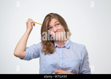 Young caucasian woman avec crayon penser la façon de résoudre un problème Banque D'Images