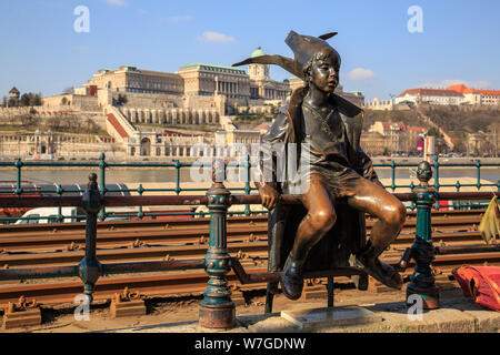 Budapest, Hongrie, le 22 mars 2018 : Statue d'un coin enfant avec un chapeau près du rail de tramway sur les rives du Danube. Banque D'Images