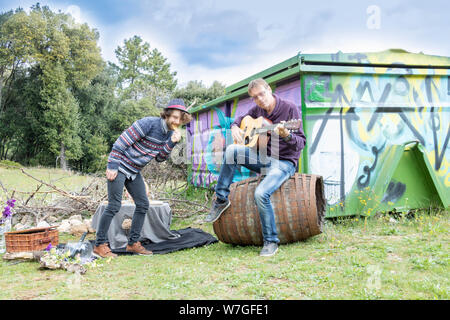 La famille, le jour de père et d'amis, pique-nique dans le pays avec un jeune homme danser tandis que son père joue de la guitare. Fête des récoltes ou anieliversary Banque D'Images