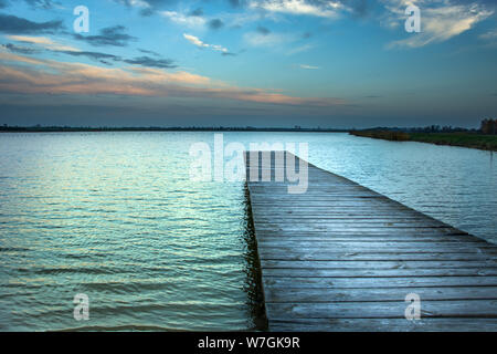 Long pont sur le lac et le ciel du soir après le coucher du soleil Banque D'Images